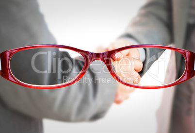 Composite image of business people shaking hands close up