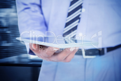 Composite image of  close up view of businessman using tablet co