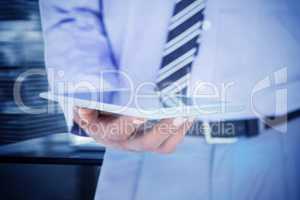 Composite image of  close up view of businessman using tablet co