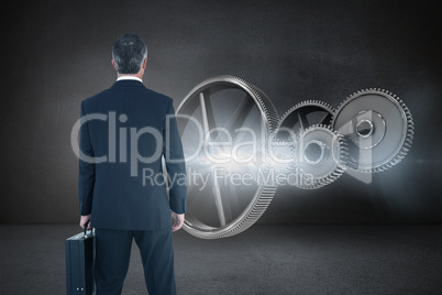 Composite image of businessman in suit holding a briefcase