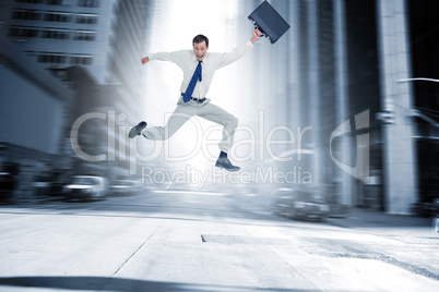 Composite image of cheerful jumping businessman with his suitcas