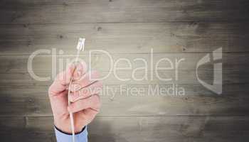 Composite image of businessman holding a cable