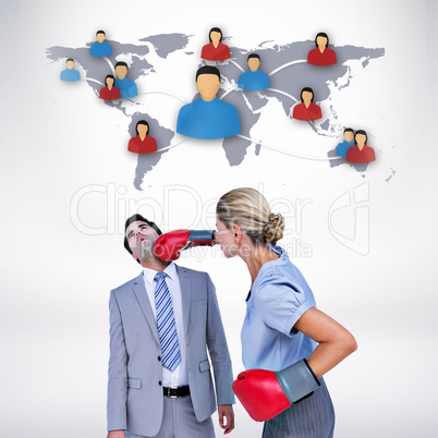 Composite image of businesswoman punching colleague with boxing