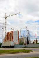 Cranes and building construction on the background of clouds