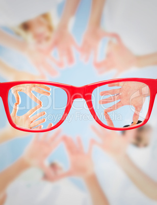 Composite image of volunteers with hands together against blue s