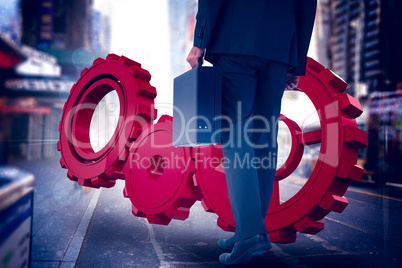 Composite image of rear view of businessman holding briefcase wa