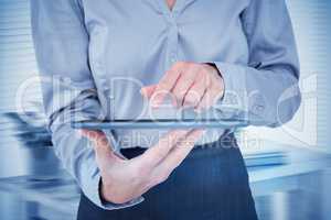 Composite image of businesswoman using her tablet