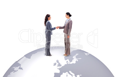 Composite image of two businesswomen shaking hands