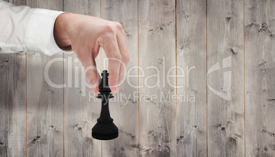 Composite image of businessmans hand moving black king