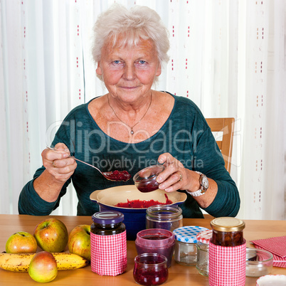 Senior woman filling homemade jam in the glass