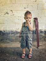 little boy with a wrench standing at the wall