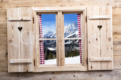 Wooden window with snowy mountain reflections