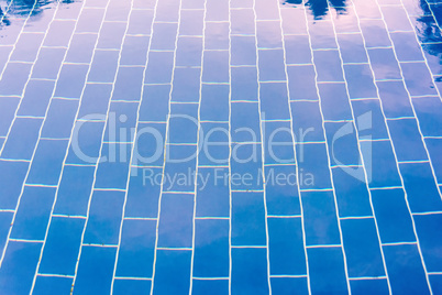 Blauer gefliester Boden eines Pools unter klarem Wasser