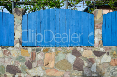 Blue wooden and stone fence