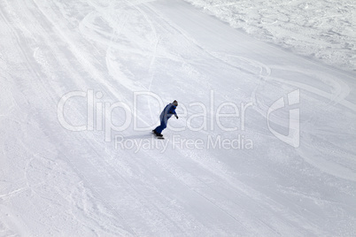 Ski slope and snowboarder at sun day