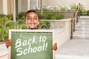 Boy Holding Back To School Chalk Board on School Campus