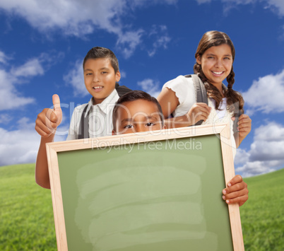 Hispanic Students with Thumbs Up in Grass Field Holding Blank Chalk Board.