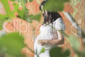 Pregnant women in front of orange wall