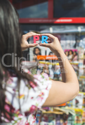 Women hold wooden letters PR