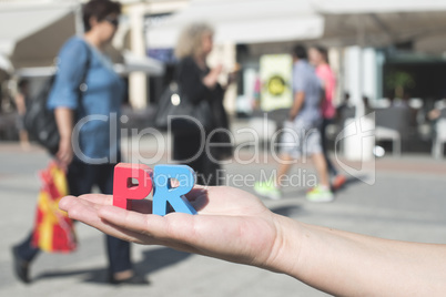 Women hold wooden letters PR