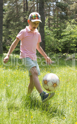 Child play with a ball in the mountain