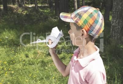 Child play with a stork made of paper