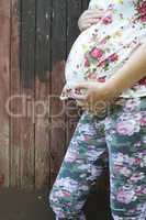 Pregnant women in front of old wooden wall