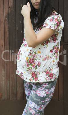 Pregnant women in front of old wooden wall