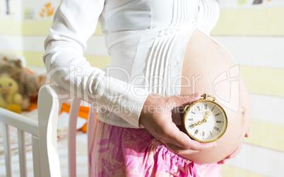 Pregnant women in a baby room.