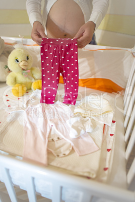 Pregnant women in a baby room.