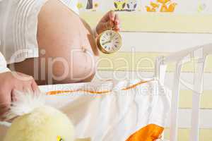 Pregnant women in a baby room.