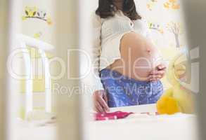Pregnant women in a baby room.