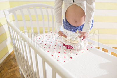 Pregnant women in a baby room.