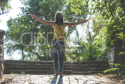 Woman with arms outstretched against sun