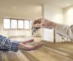 Realtor giving house key to buyer in empty room