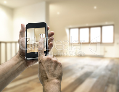 Smarthphone with man hand taking picture in modern loft studio