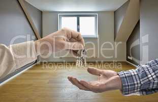 Realtor giving house key to buyer in empty room