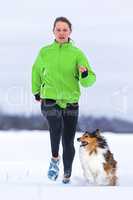 Joggerin mit Hund im Schnee