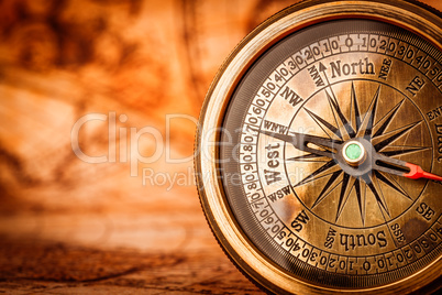 Vintage compass lies on an ancient world map.