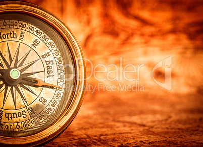 Vintage compass lies on an ancient world map. Vintage compass lies on an ancient world map.