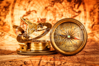 Vintage compass lies on an ancient world map.