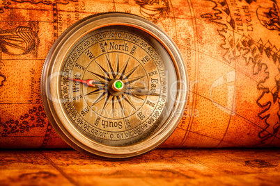 Vintage compass lies on an ancient world map.