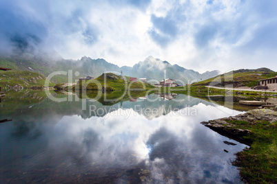 Idyllic view with typical lodges on Balea Lake shore in Fagaras