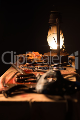 Lamp, knife and  mask on the table a gray background