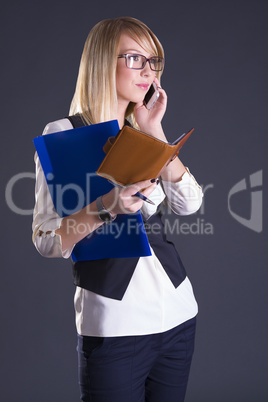 blonde with a notebook in hand on gray background