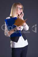 blonde with a notebook in hand on gray background