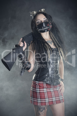 girl with dreadlocks and with a gun in his hand on a gray background