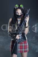 girl with dreadlocks and with a gun in his hand on a gray background