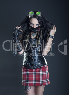 Brunette girl with dreadlocks on a gray background