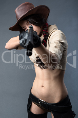 Cowboy woman to aim a gun on gray background